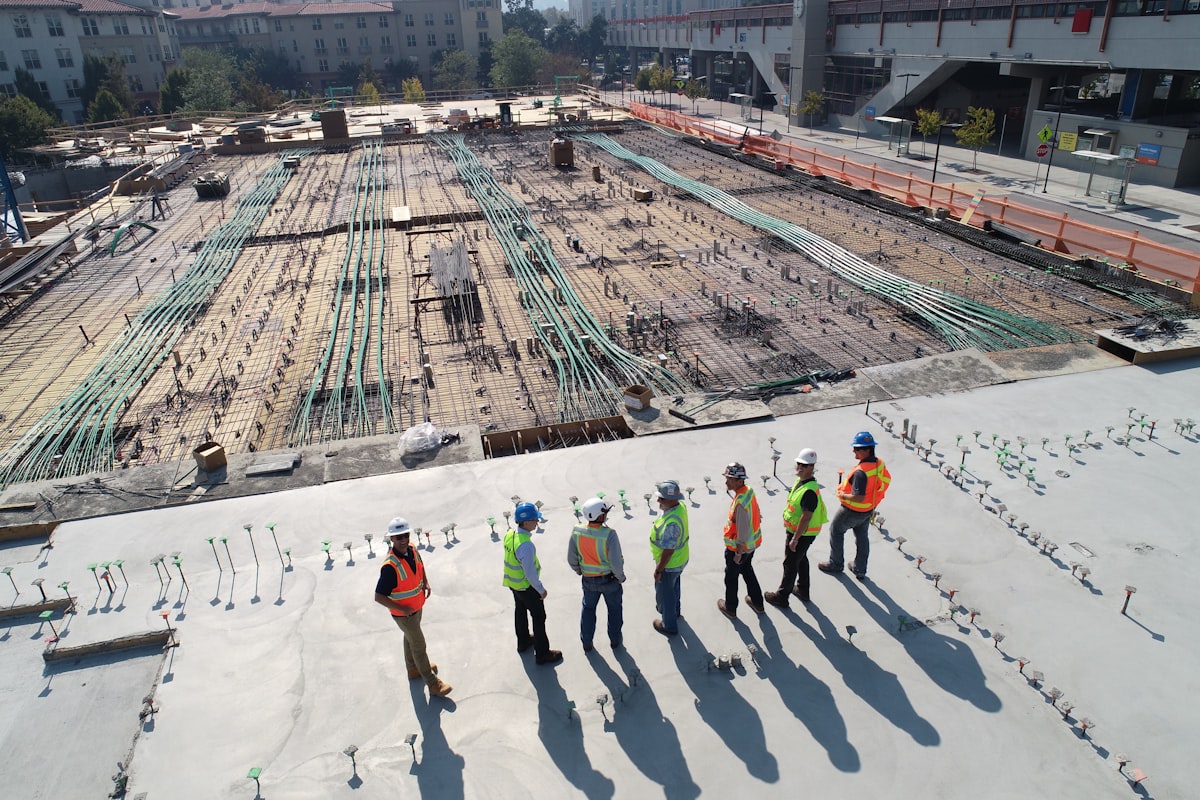Construction workers in hi-vis reviewing plans on site